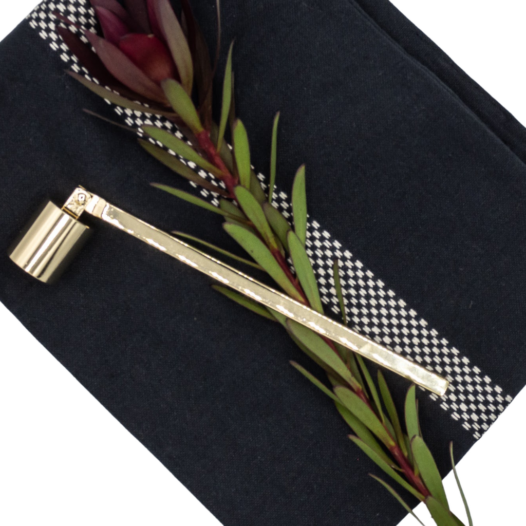 Gold Candle Snuffer on black tea towel